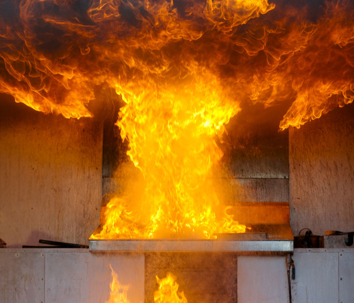 Kitchen stovetop fire with flames reaching the ceiling