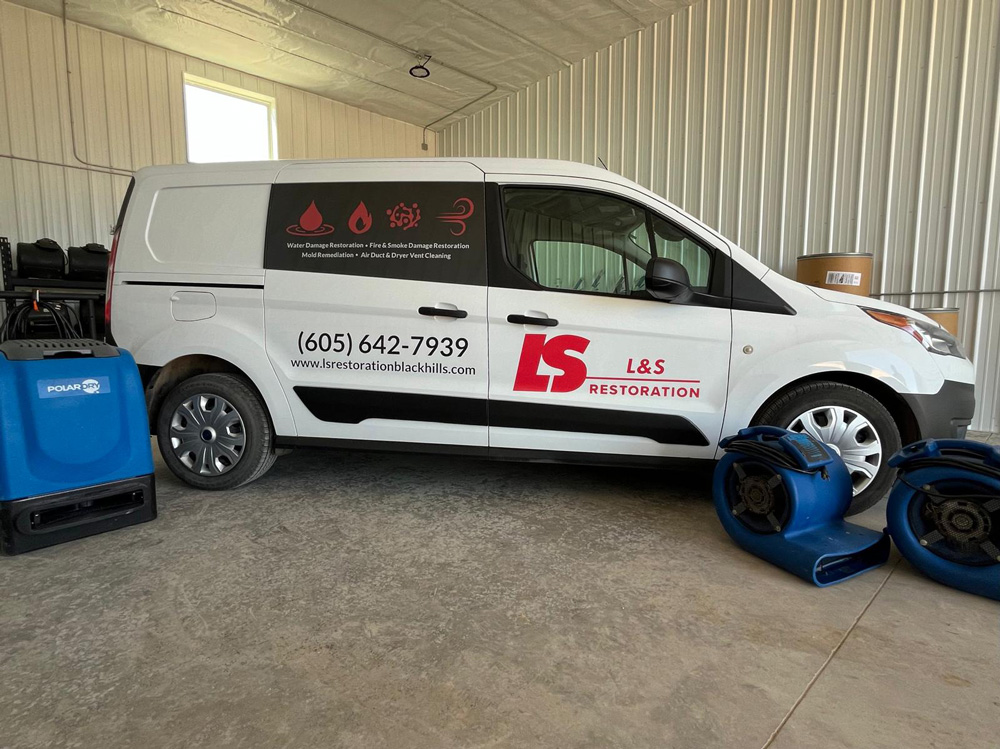 L&S Restoration service van with dehumidifier and air movers in the company shop